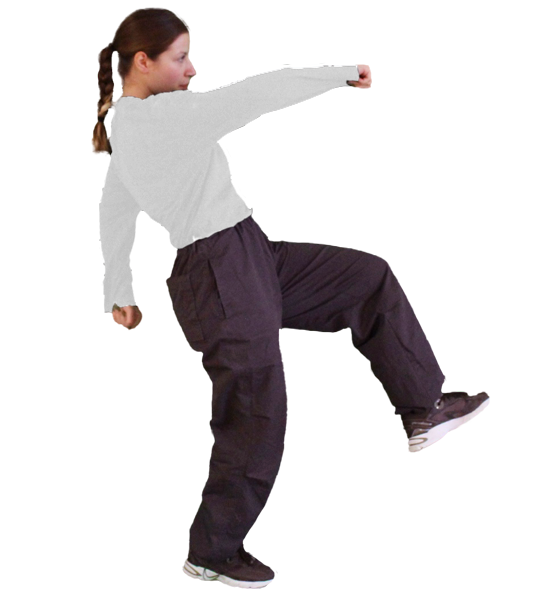 Une personne effectue un mouvement dynamique de danse K-pop, vêtue d'un t-shirt blanc et de pantalons noirs, avec des baskets.